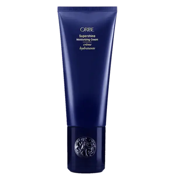 Oribe Supershine Moisturizing Cream i en blå tube med guldtekst, der beskriver produktet som en fugtgivende creme